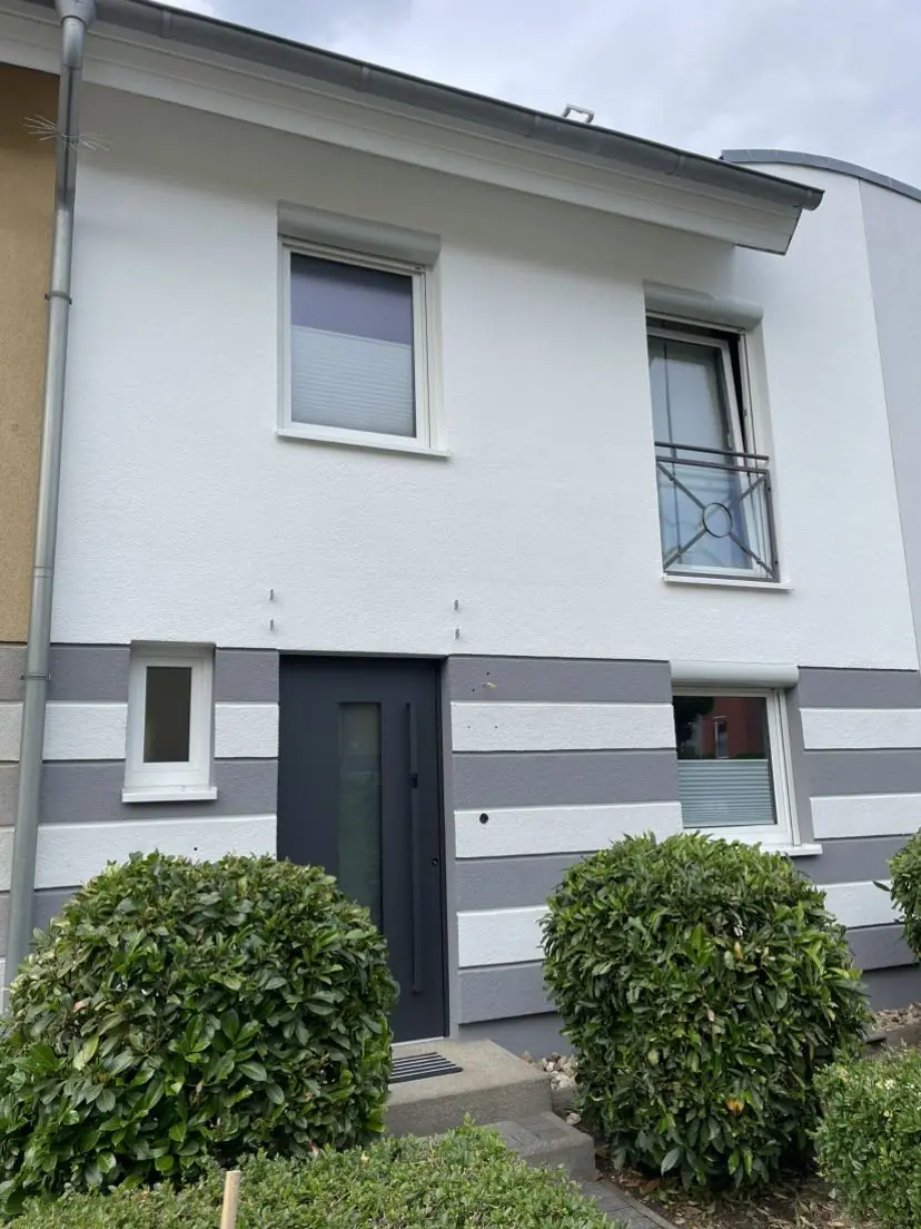 Fassade nach der Modernisierung in Grau und Weiß